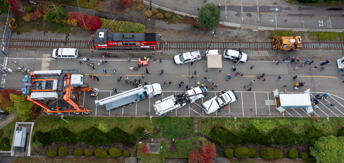 An overhead shot of a street filled with large vehicles and people.